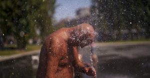 Un hombre se enfría con agua de fuente en el parque de Río en madrid, españa, el 26 de junio de 2023, hora local.